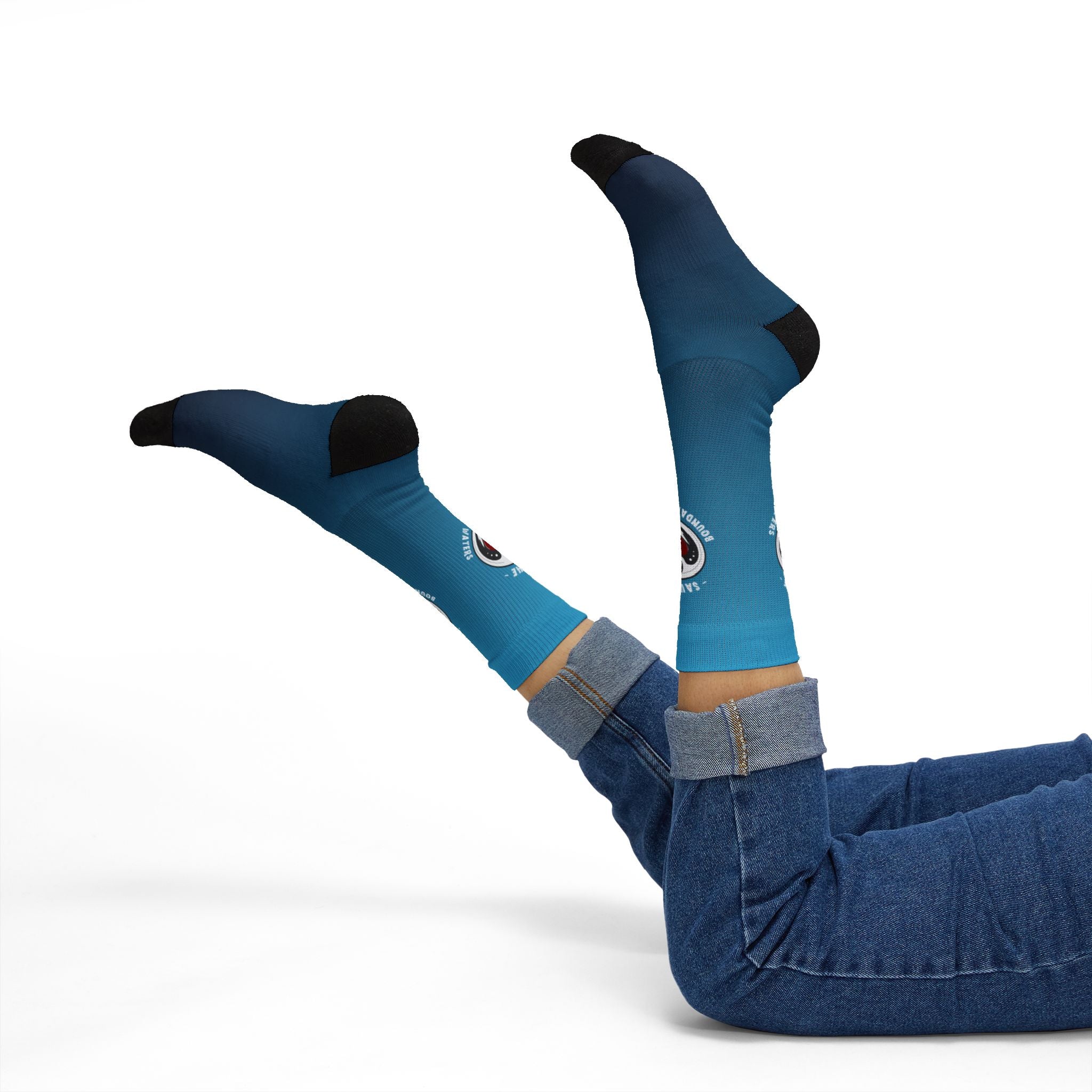 Lifestyle photo of Minnesota flag blue crew socks with BWCA rebel loon illustration on model raising feet