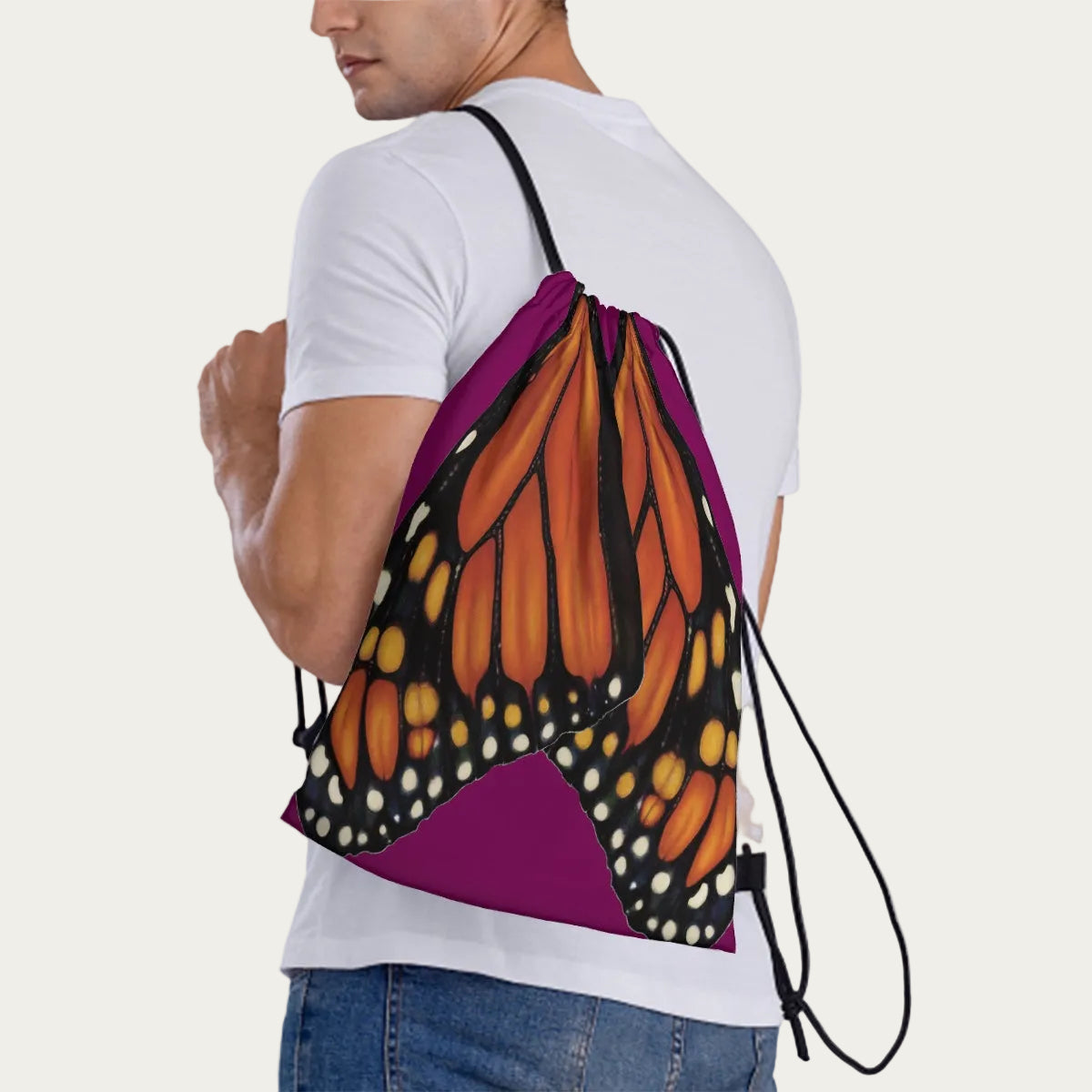 Model wearing plum drawstring backpack slung over one shoulder, showing side view of the monarch wing artwork.