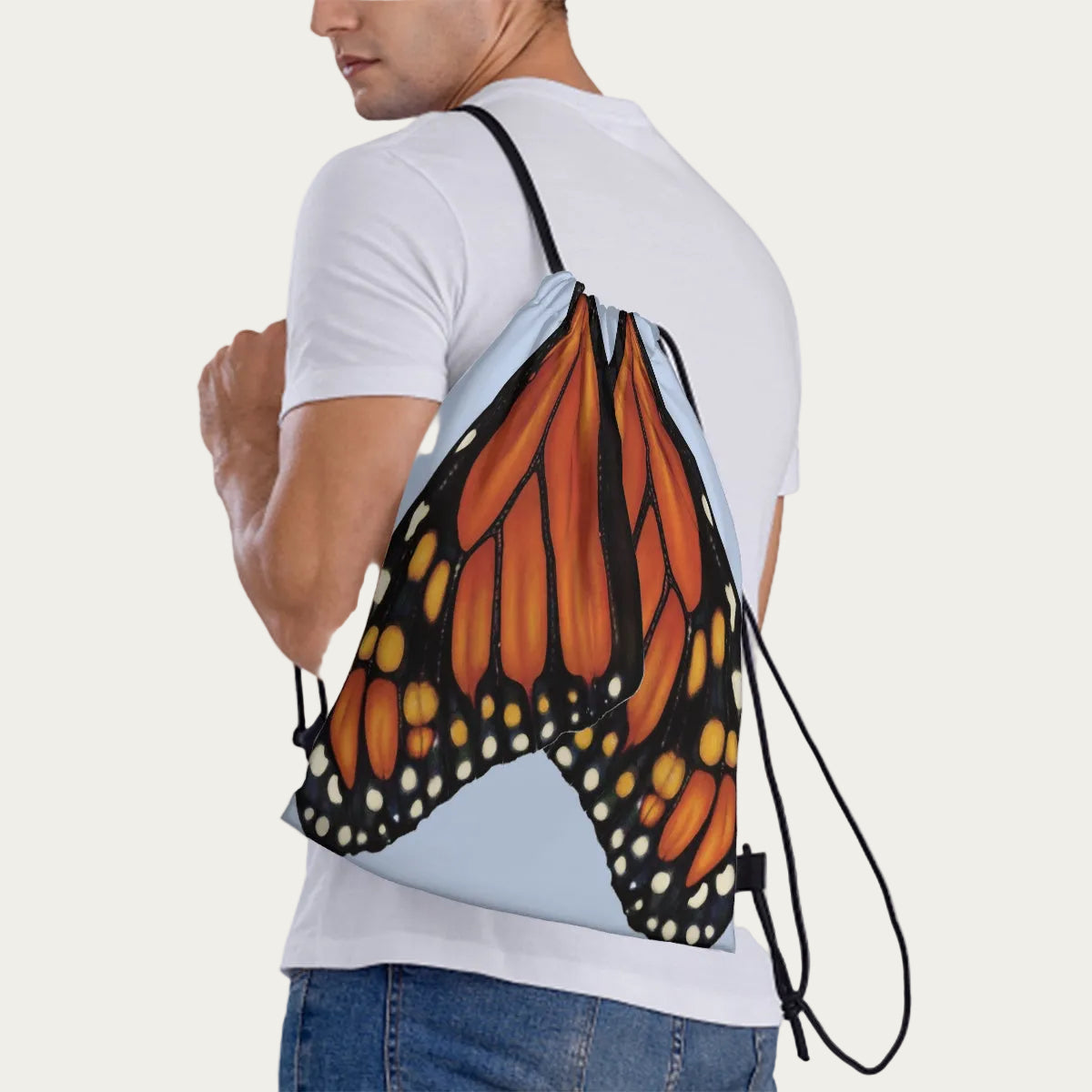Model wearing sky‑blue drawstring backpack slung over one shoulder, showing side view of the monarch wing design.