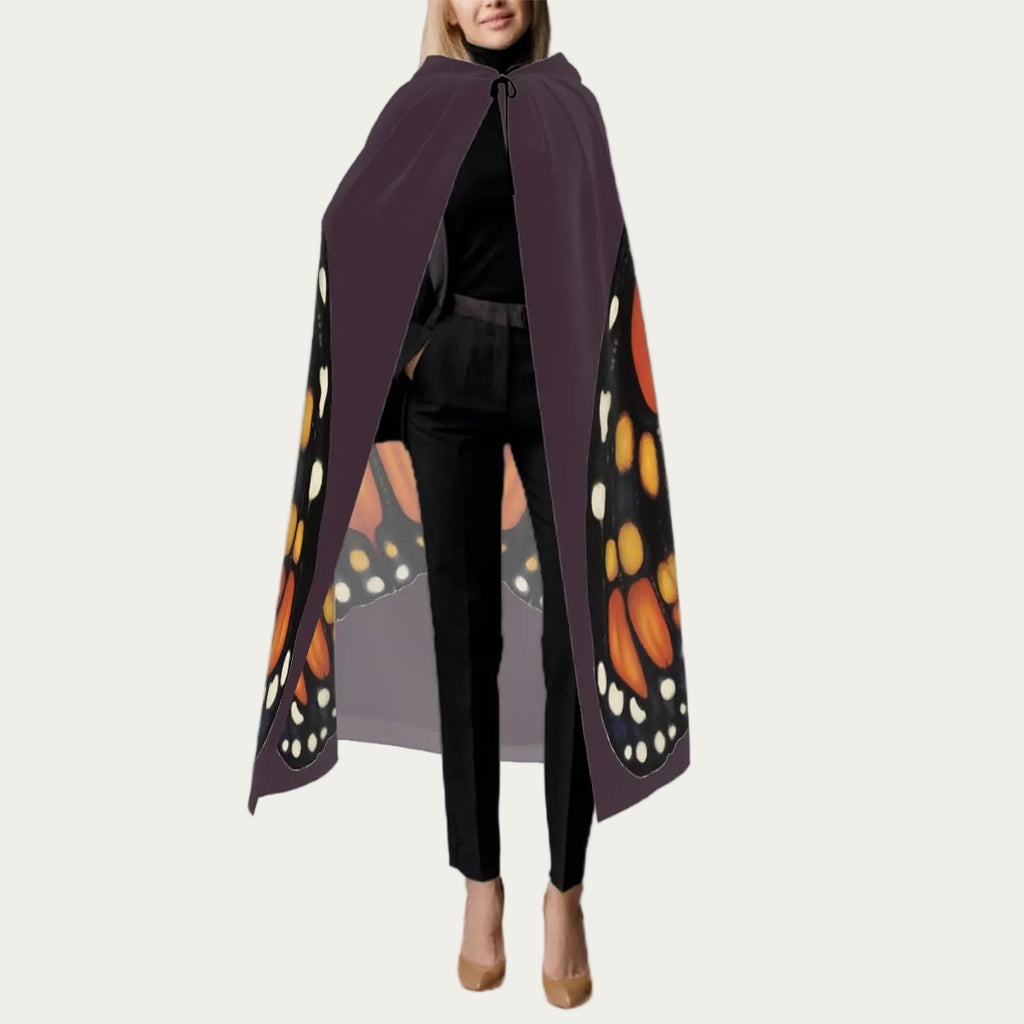 Front view of model wearing plum hooded floor‑length cape with tie closure at the neck and smooth front drape.