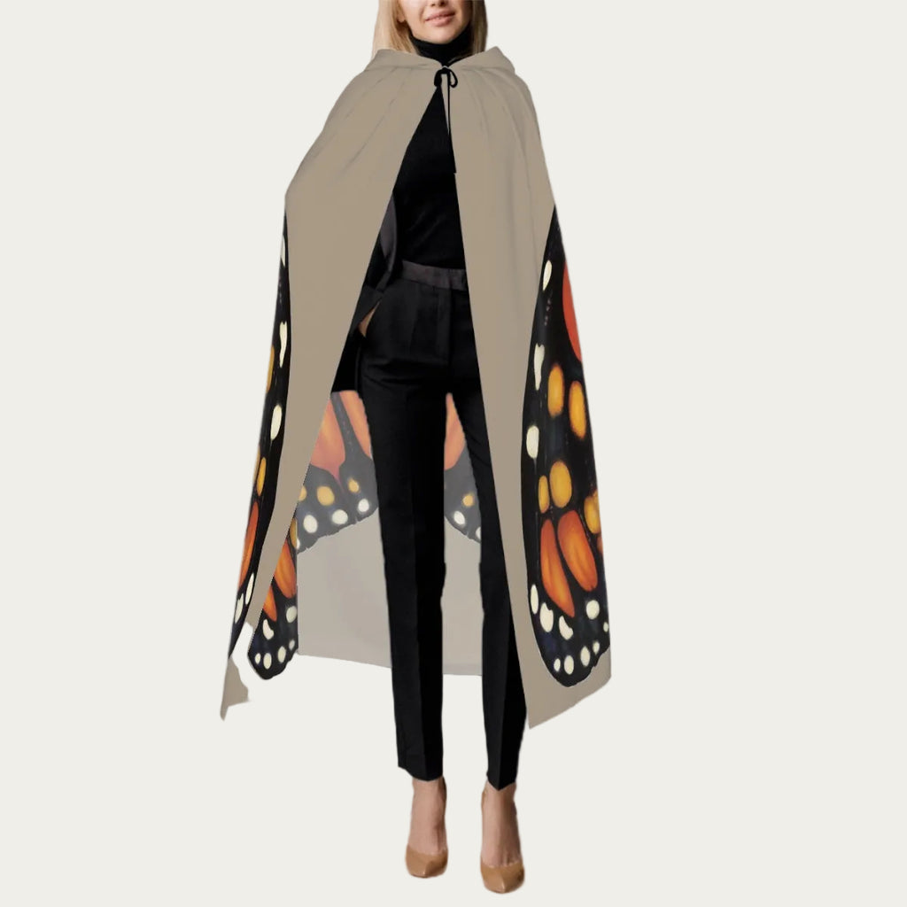 Front view of model wearing sand hooded floor‑length cape with tie closure at the neck and smooth front drape.