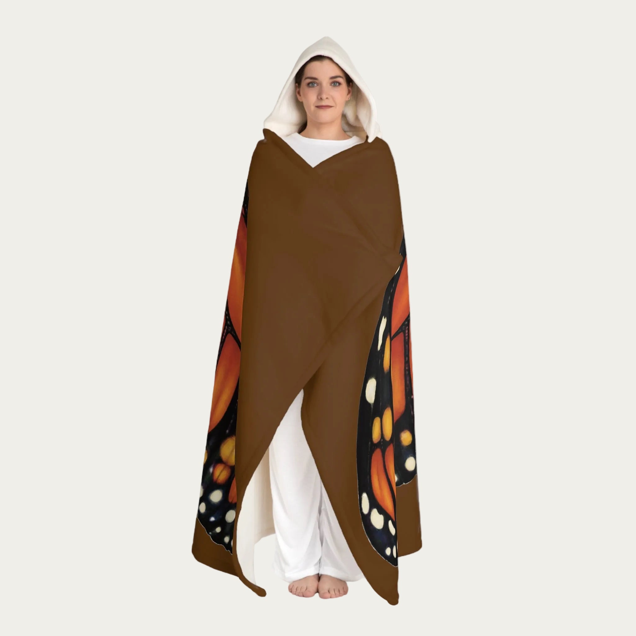 Model standing front view with brown hooded sherpa blanket wrapped around their body, showing cream sherpa hood and plush fleece texture.