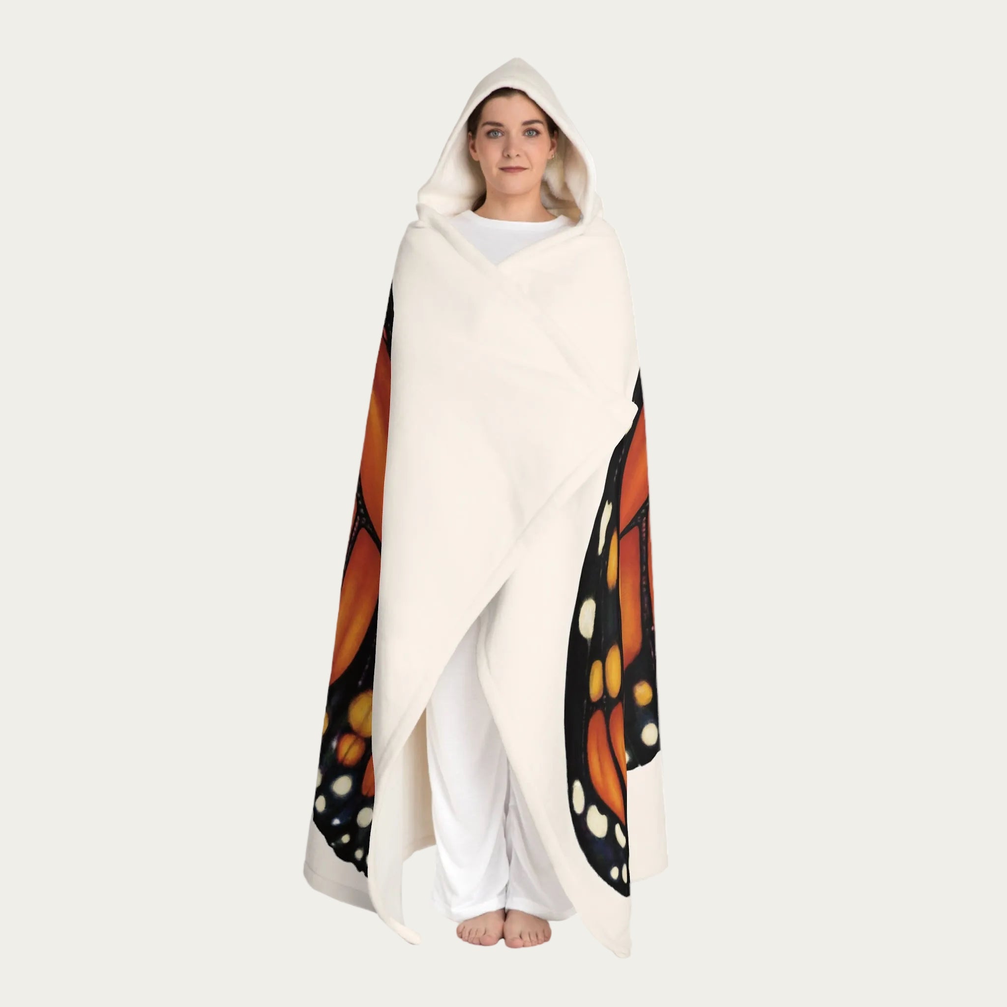 Model standing front view with cream hooded sherpa blanket wrapped around their body, showing plush fleece texture and cream sherpa hood.