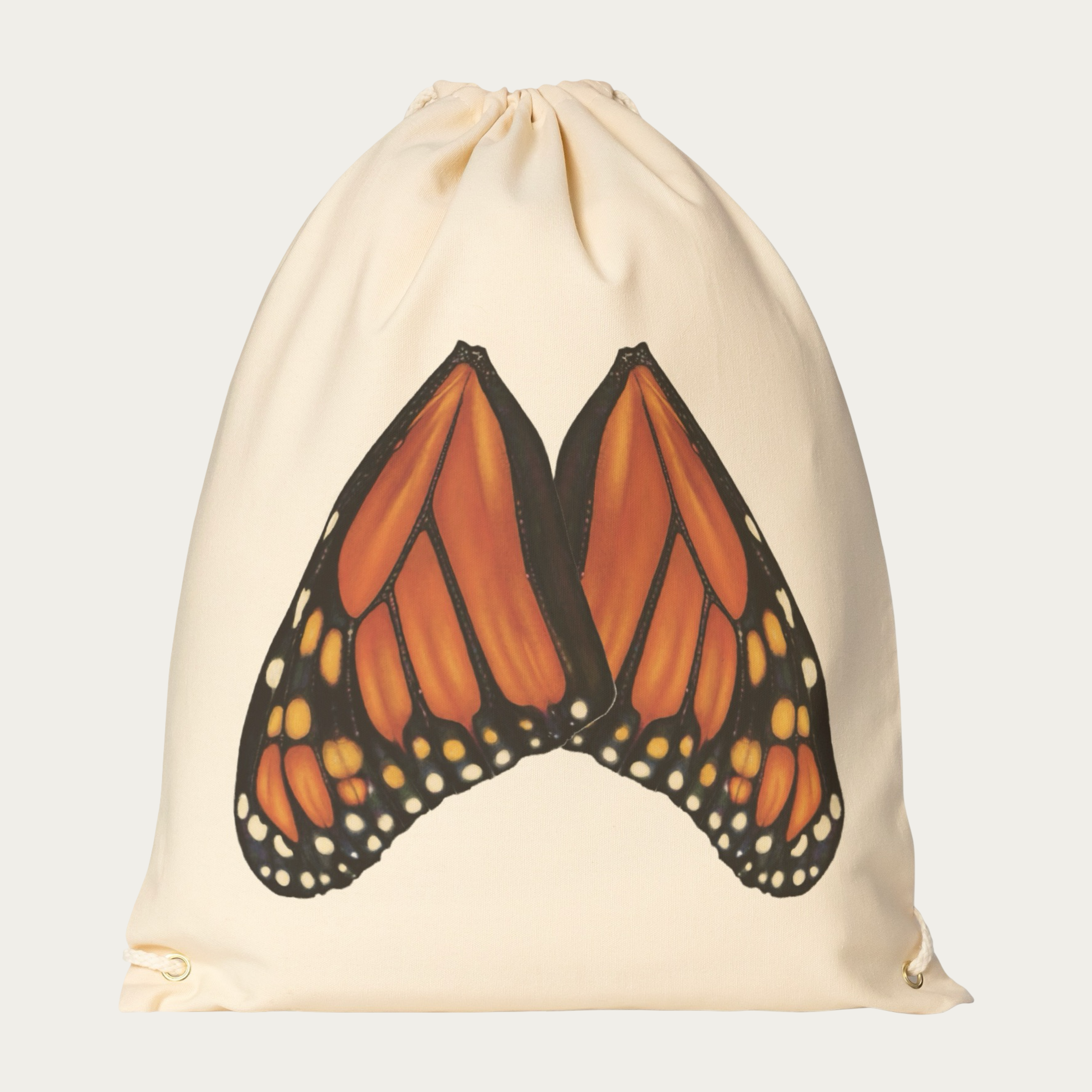 Floating view of natural‑canvas drawstring backpack with monarch butterfly wings printed in natural alignment across the back.