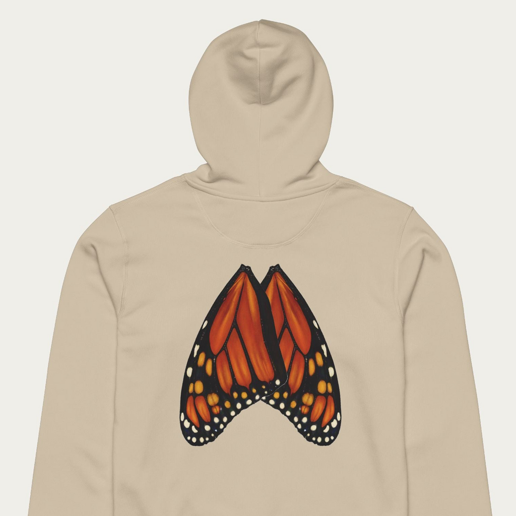 Close-up flat lay of desert dust hoodie with monarch butterfly wings printed in natural wing alignment across the back.