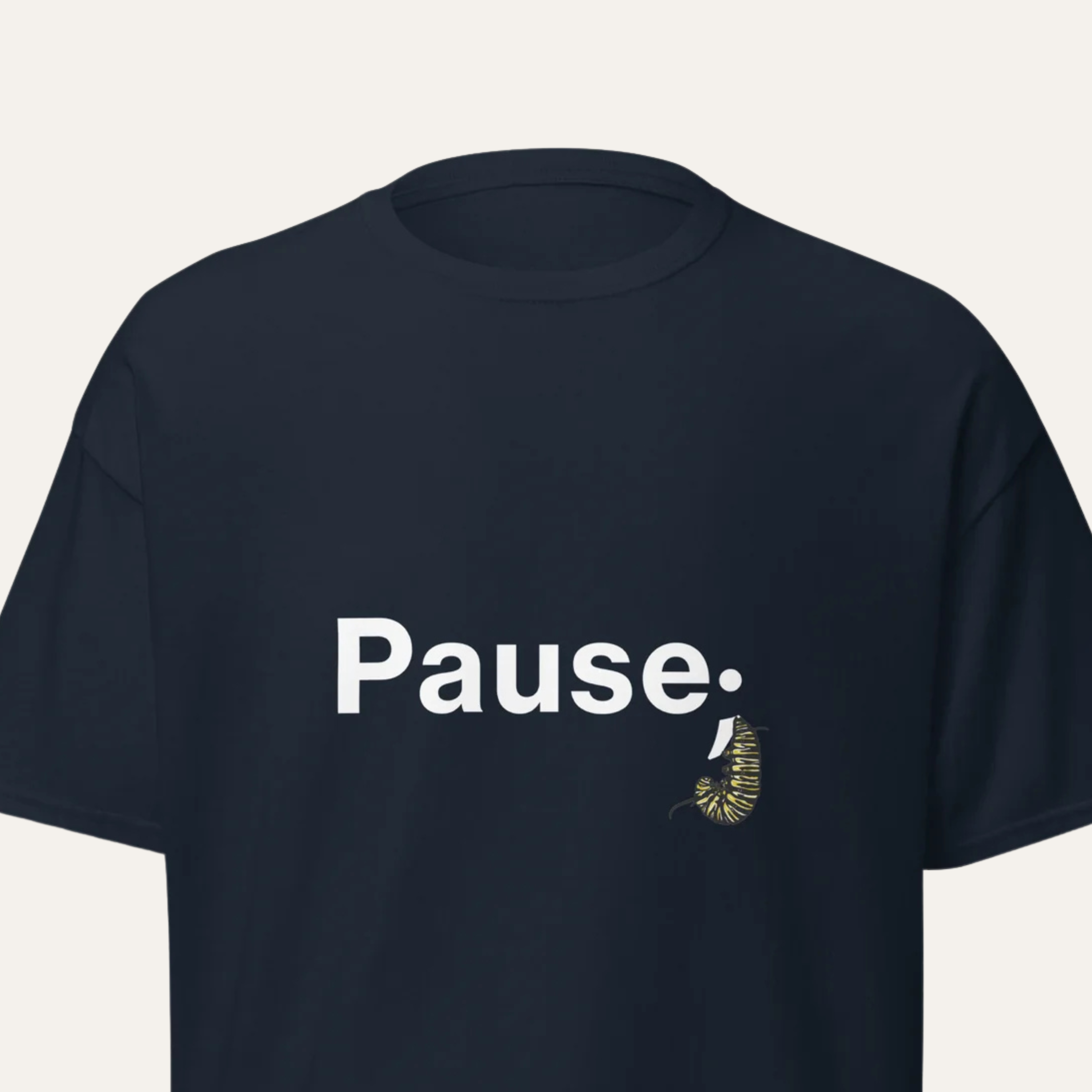 Close‑up crop of navy tee showing detailed monarch caterpillar illustration curled into a semicolon shape.