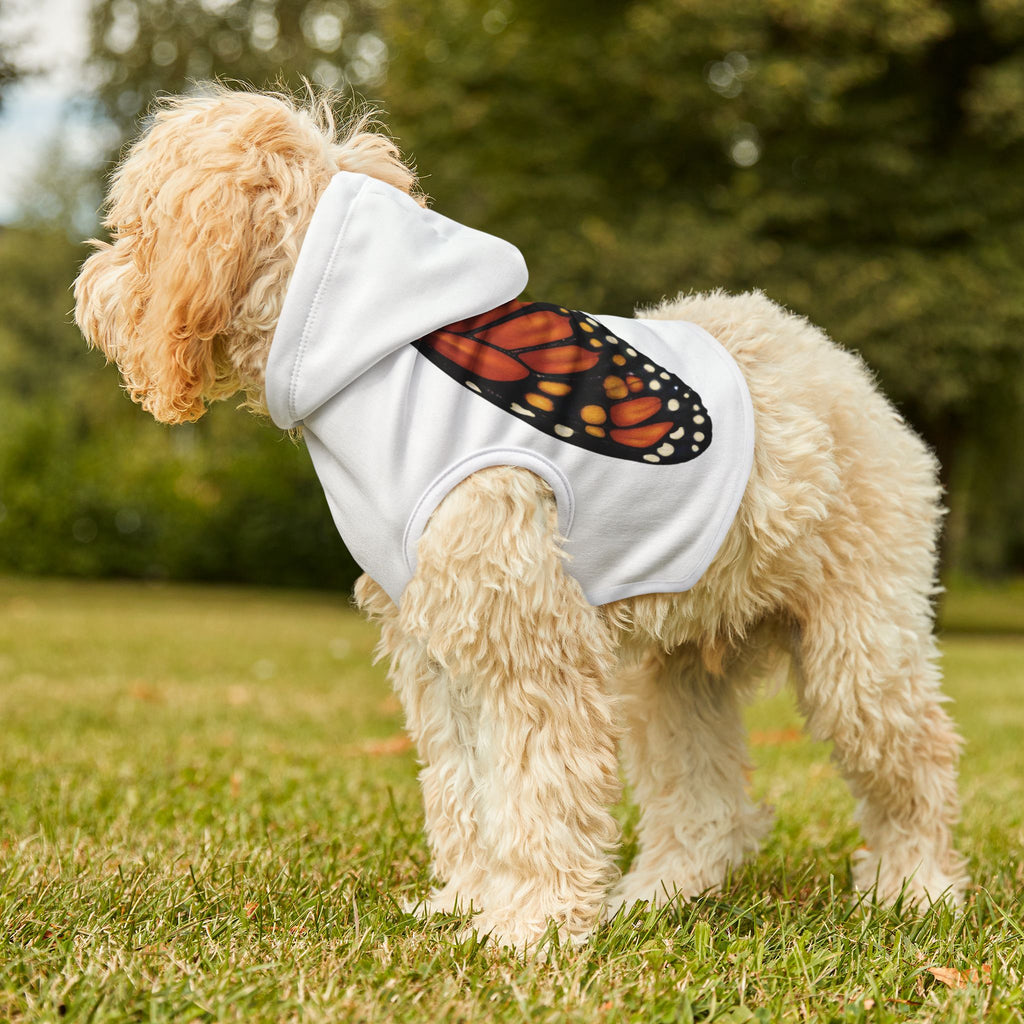 Dog standing outside wearing white pet hoodie with monarch butterfly wings printed naturally across the back.