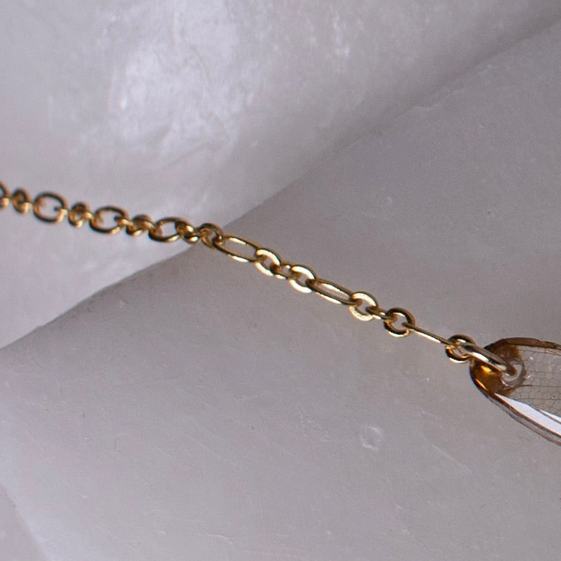 dragonfly necklace turquoise pearl gold chain close up on wax background