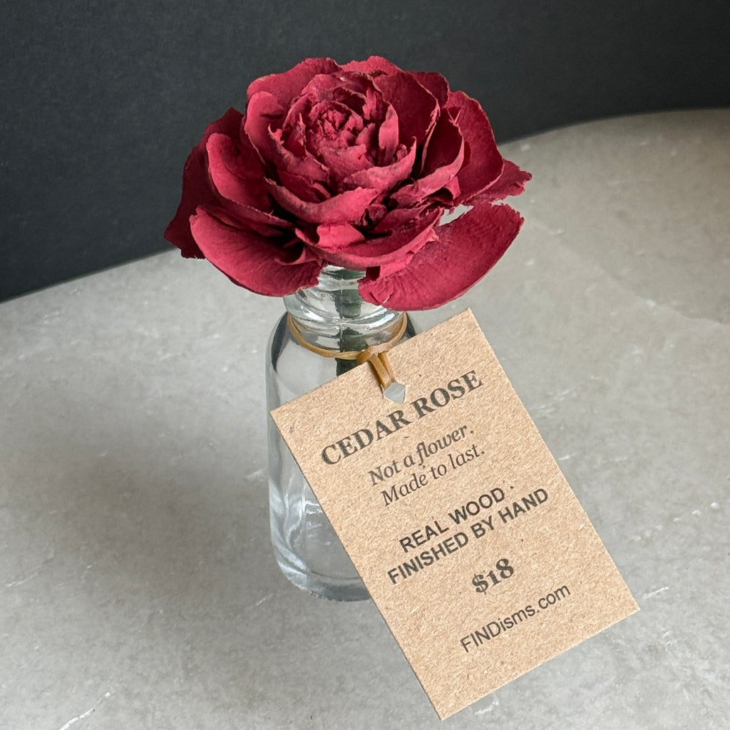 Cedar Rose in glass with kraft tag reading Not a flower. Made to last. Real wood. Finished by hand.