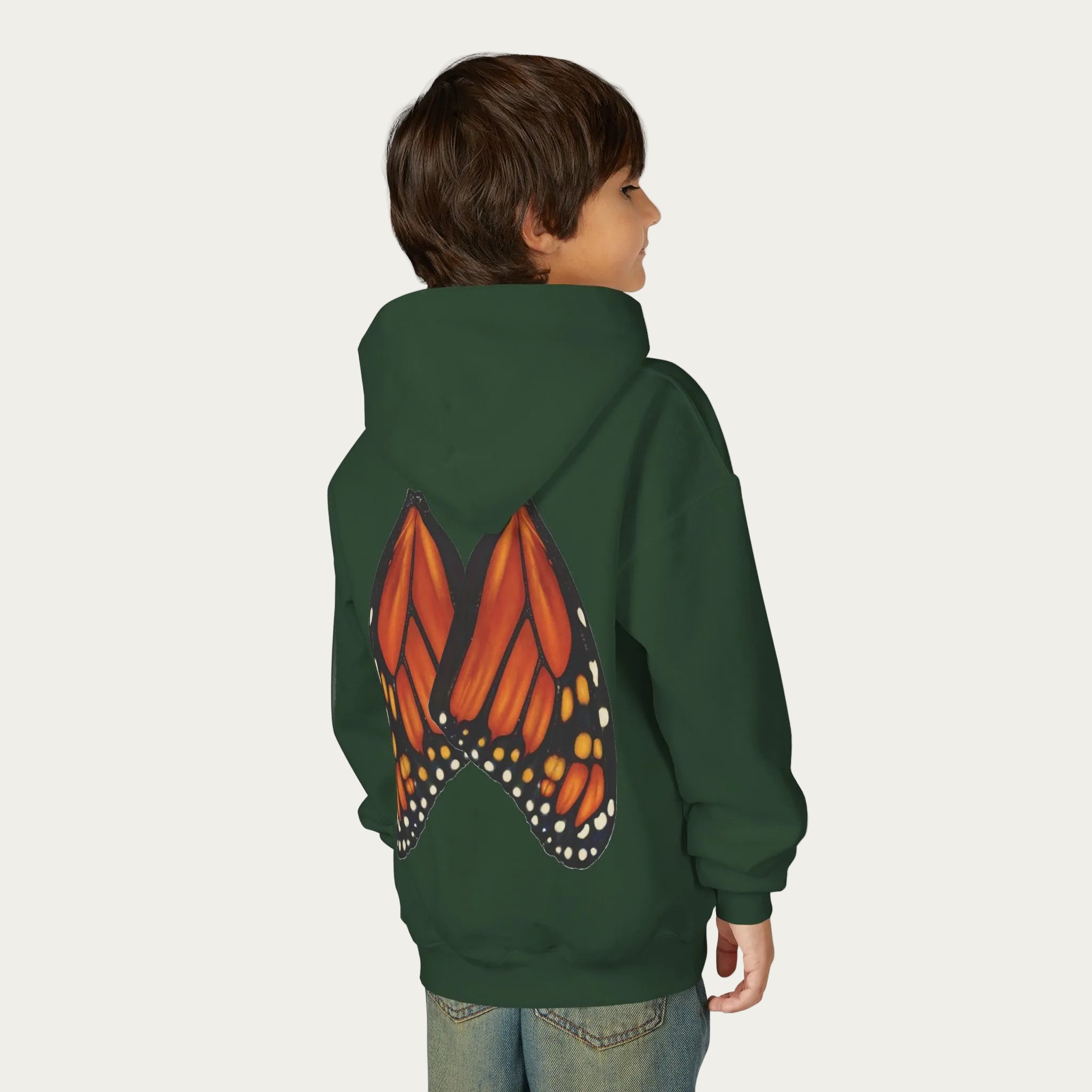 dark green kids hoodie with artist illustrated monarch butterfly wings on back on boy model white background