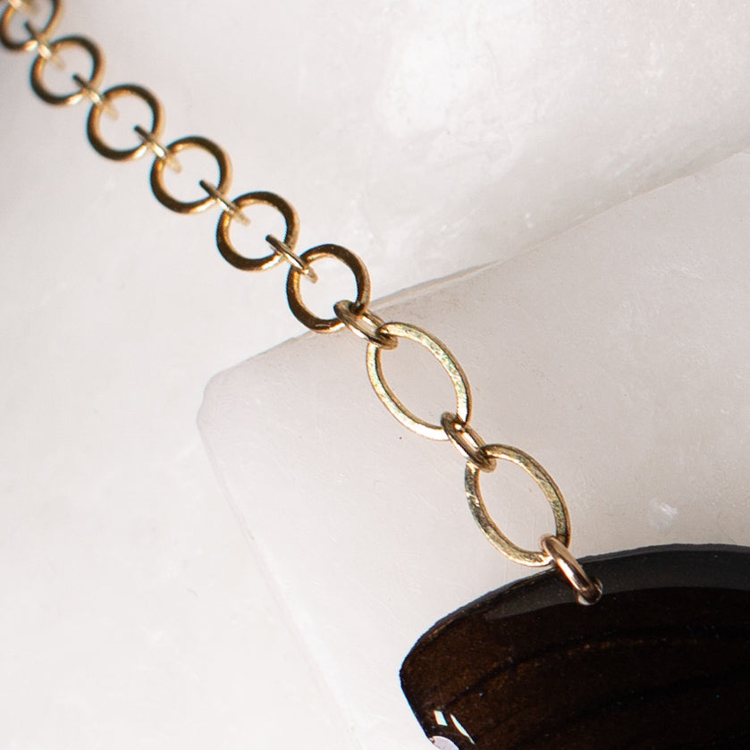 real butterfly wing necklace gold chain close up on wax background